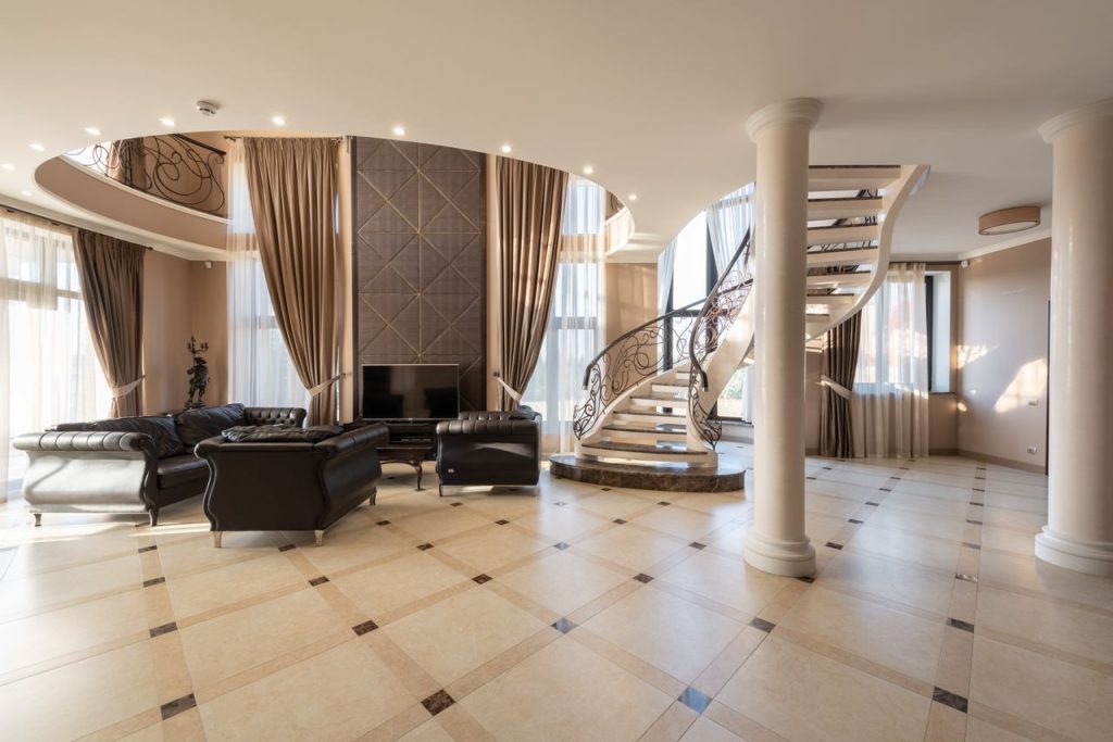 The Art of Drawing Readers In: Your attractive post title goes here Interior of spacious hallway of classic styled villa with columns and comfortable leather sofa and armchair placed near spiral staircase