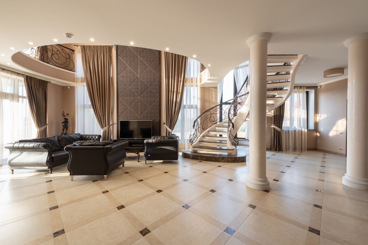 The Art of Drawing Readers In: Your attractive post title goes here Interior of spacious hallway of classic styled villa with columns and comfortable leather sofa and armchair placed near spiral staircase